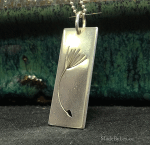 A dandelion seed cut-out on a 18" sterling silver chain. 3x1cm. $50.