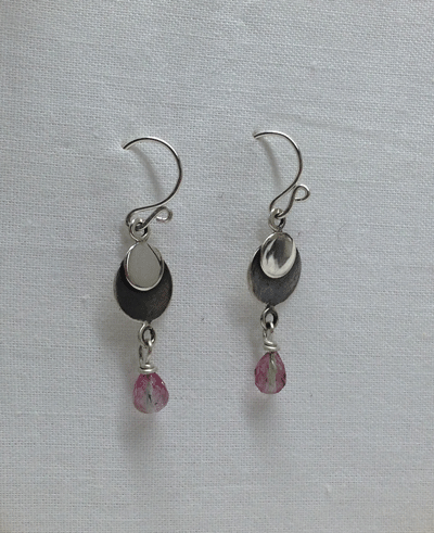 Delicate pink and blue tourmaline stones hanging from silver disks. Lower disks are patinated black. $45