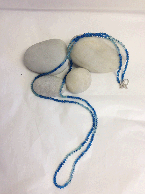 Small faceted apatite beads hand tied (a knot between each bead) into a long 32" necklace. Silver s-clasp. $120